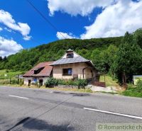 Commercial premises in Mýto pod Ďumbierom by the road, surrounded by greenery and trees.