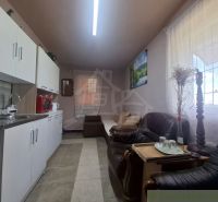 A kitchen unit in a cottage with sofas and decoration, floor with wooden decor.
