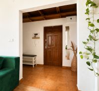 The entrance hall in a 3-room apartment with a green sofa and decorations.