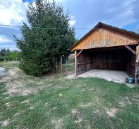 Wooden shelter in the exterior of a 2-room apartment in the village of Telince with a conifer.