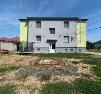 A two-story building in Telince with a yard, a trampoline, and a swing.