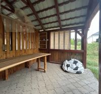 A wooden shelter in Telince and a 2-room apartment with a stone floor in the background.