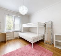 Children's room in a 3-room apartment with a bunk bed, yellow chair, shelves, and a wooden decor floor.