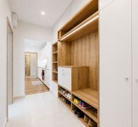 A hallway with a shoe cabinet and a wardrobe in a 3-room apartment, wood decor and white elements.