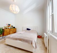A bright bedroom with a bed, a cabinet, and a window in a 3-room apartment.