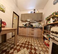 A kitchen in a family house with tiles and furniture in a wooden decor.