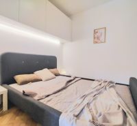 A bedroom with a comfortable bed, a white wardrobe, and decoration in a two-room apartment.
