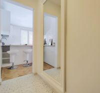 Bar stools in the kitchen at the counter, 2-room apartment, floor with wooden decor.