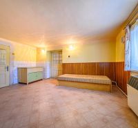 A room in a family house with one bed, a cabinet, and laminate flooring.