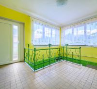 Yellow walls, green metal railing, tiled floor, bright space in a family house.
