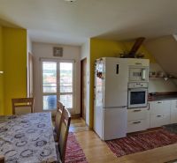 A kitchen in a 2-room apartment with a wooden decor and a yellow wall.