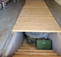 A cellar with a wooden hatch and details on stored items.