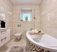 Elegant bathroom in a 2-room apartment with a bathtub, sink, and toilet.