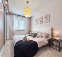 Bedroom in a 2-room apartment with a wooden decor floor and wall decoration.