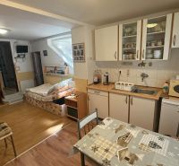 Kitchen corner with cabinets, table, and sofa, wooden decor flooring in a family house.
