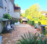 A family house in Zvolen with a paved courtyard and a garden seating area.
