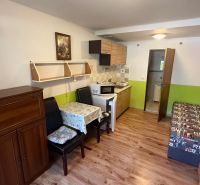 Interior with a kitchenette, table, and wooden decor flooring in a family house.