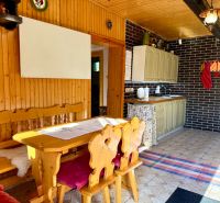 Wooden interior of a kitchen with a dining table and chairs in a family house.