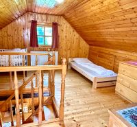 The attic of a family house with wooden paneling and a floor with a wood decor.