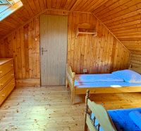 An attic room in a family house with wooden decor and simple furnishings.