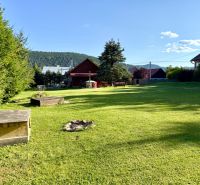 The garden at the family house on Jána Švermu Street in Šumiac with a lawn and a fireplace.