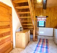 Interior of a family house with wooden staircase, ceiling, and doors, tiled floor.