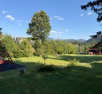 A family house in Šumiac on Jána Švermu Street, a grassy garden with a playground surrounded by nature.