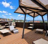 Rooftop terrace with a view of Bratislava-Dúbravka with comfortable seating and a sunshade.