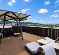Terrace in Bratislava - Dúbravka on Nejedlého with loungers and a view of the city.