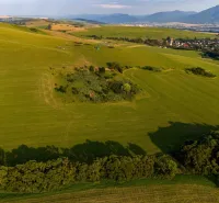 Extensive green fields and hills in Liptovský Trnovec, offering a view of peculiar properties.