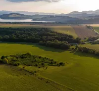 A landscape in Liptovský Trnovec with greenery, forests, and hills. Unique properties.