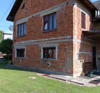 A family house in Ovčiarsko with an unplastered brick facade and a green lawn for the plots - living.
