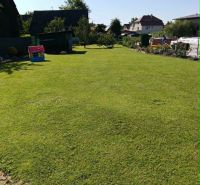 A flat lawn on a residential plot in Ovčiarsko with surrounding houses in the countryside.