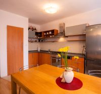 A kitchen in a 4-room apartment with a wooden decor and a yellow floral accessory.