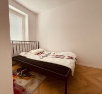 A bedroom with an iron bed and a wooden decor floor in a 4-room apartment.