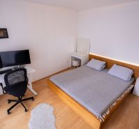 Bedroom with a bed, desk, and wooden decor flooring in a 4-room apartment.