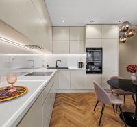 A kitchen in a 3-room apartment with a wood-patterned floor and elegant lighting.