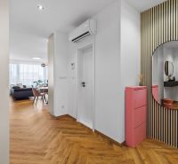 Entrance hall with wood-patterned flooring, a mirror, and a pink shoe cabinet in a 3-room apartment.