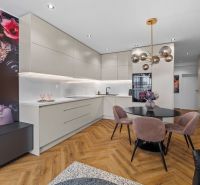 A kitchen in a 3-room apartment with a wooden decor floor and a dining table.