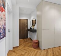 Entrance hall in a 3-room apartment with wood-patterned flooring and a colorful painting.
