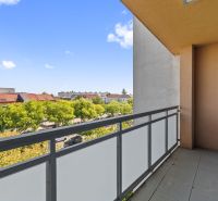 A balcony with a view of greenery and rooftops at Námestie 1. mája in Senec from a 3-room apartment.