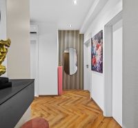 A hallway in a 3-room apartment with decoration, a floral painting, and a floor with a wooden decor.