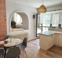 A dining room in a family house with a vaulted opening and a wooden decor floor.
