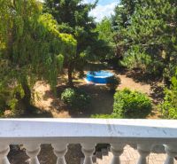 View from a family house in Mankovce to a green garden with a swimming pool.