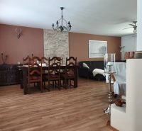 Dining room in a family house with a wooden decor floor and solid furniture.