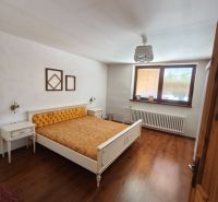 Bedroom with a bed and wood-decor flooring in a family house.