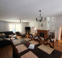 Living room with a fireplace in a family house and a floor with a wooden decor.