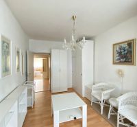 A living room with light furniture in a 4-room apartment and a floor with a wooden decor.