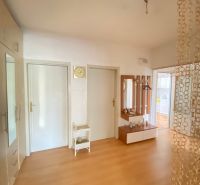 Entrance hall of a 4-room apartment with a wooden decor floor and a mirror.