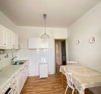 A kitchen in a 4-room apartment with white cabinets and a wood-patterned floor.